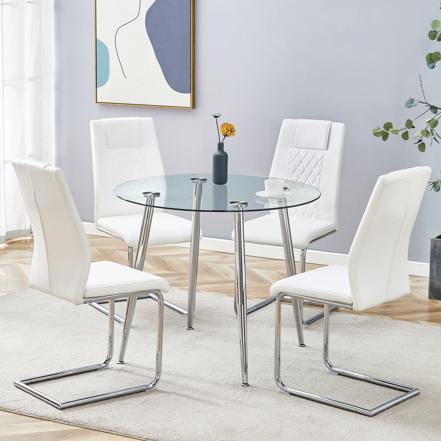 A modern minimalist round transparent tempered glass table with silver metal legs and 4 white modern PU leather high-backed dining chairs for a luxurious experience.
