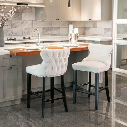 A&A Furniture, Contemporary Velvet Upholstered Wing-Back Barstools with Button Tufted Decoration and Wooden Legs, and Chrome Nailhead Trim - Beige
